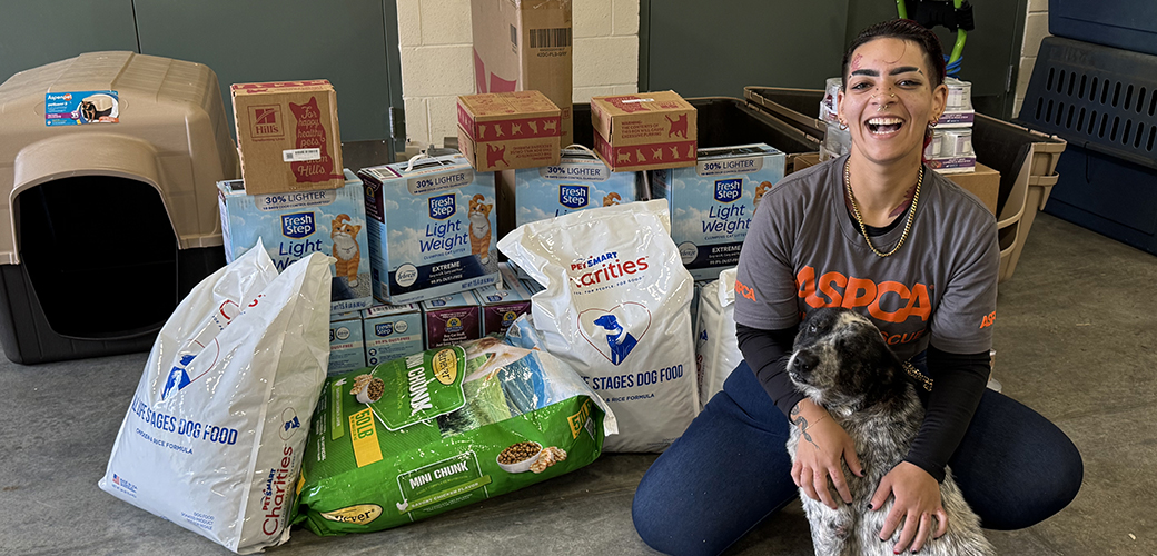 ASPCA responder with dog and donated supplies