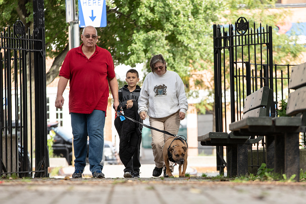 Robert, Maria and their grandson walk Orson through their neighborhood in Queens
