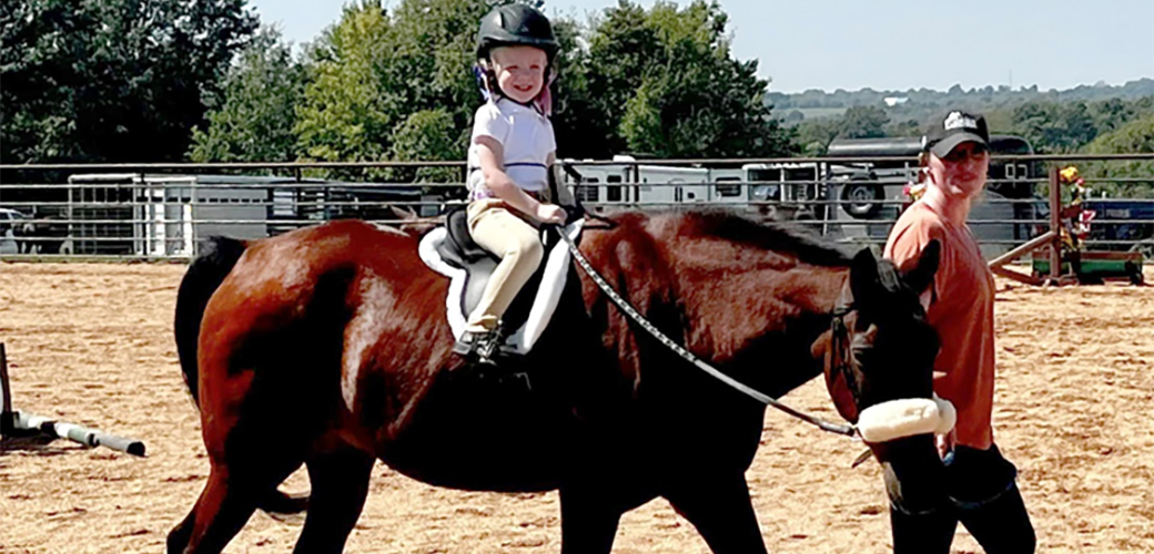 Katie's niece riding Gramps while Katie leads him