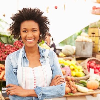 woman next to vegetable display