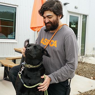 ASPCA staff member with a black dog