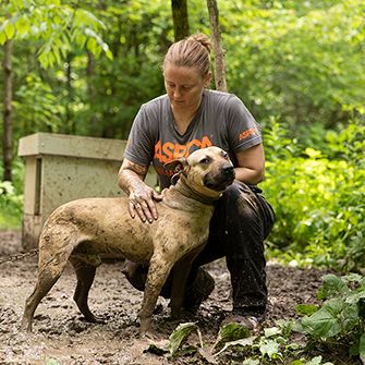 an aspca responder with a dog chained in mud