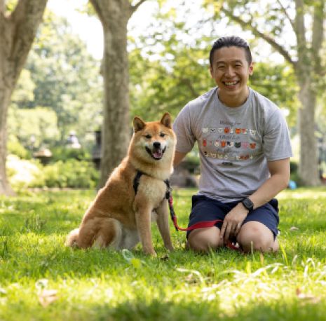 a man with a shiba inu in a park